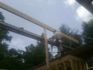 Carpenter setting a ridge beam over a new addition frame — Ice Dam Removal by Roofing Brothers in Leipsic