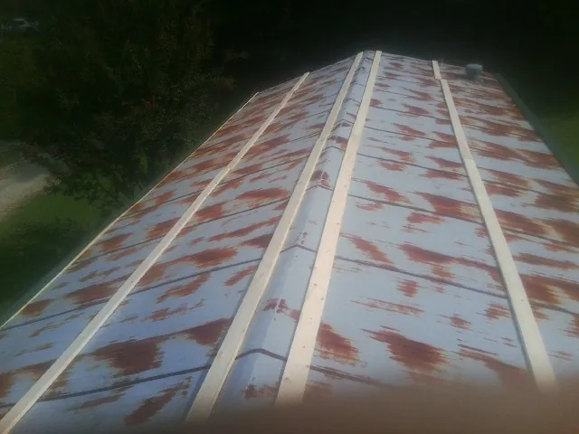 Rusted metal roof panels with new wood purlins before replacement — Storm Damage Roof Repair in Leipsic by Roofing Brothers