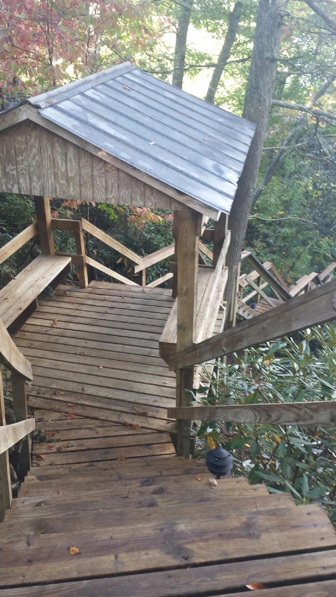 Metal roofed shelter over wooden steps on a wooded walkway — Skylight Repair & Installation work by our crew in Leipsic